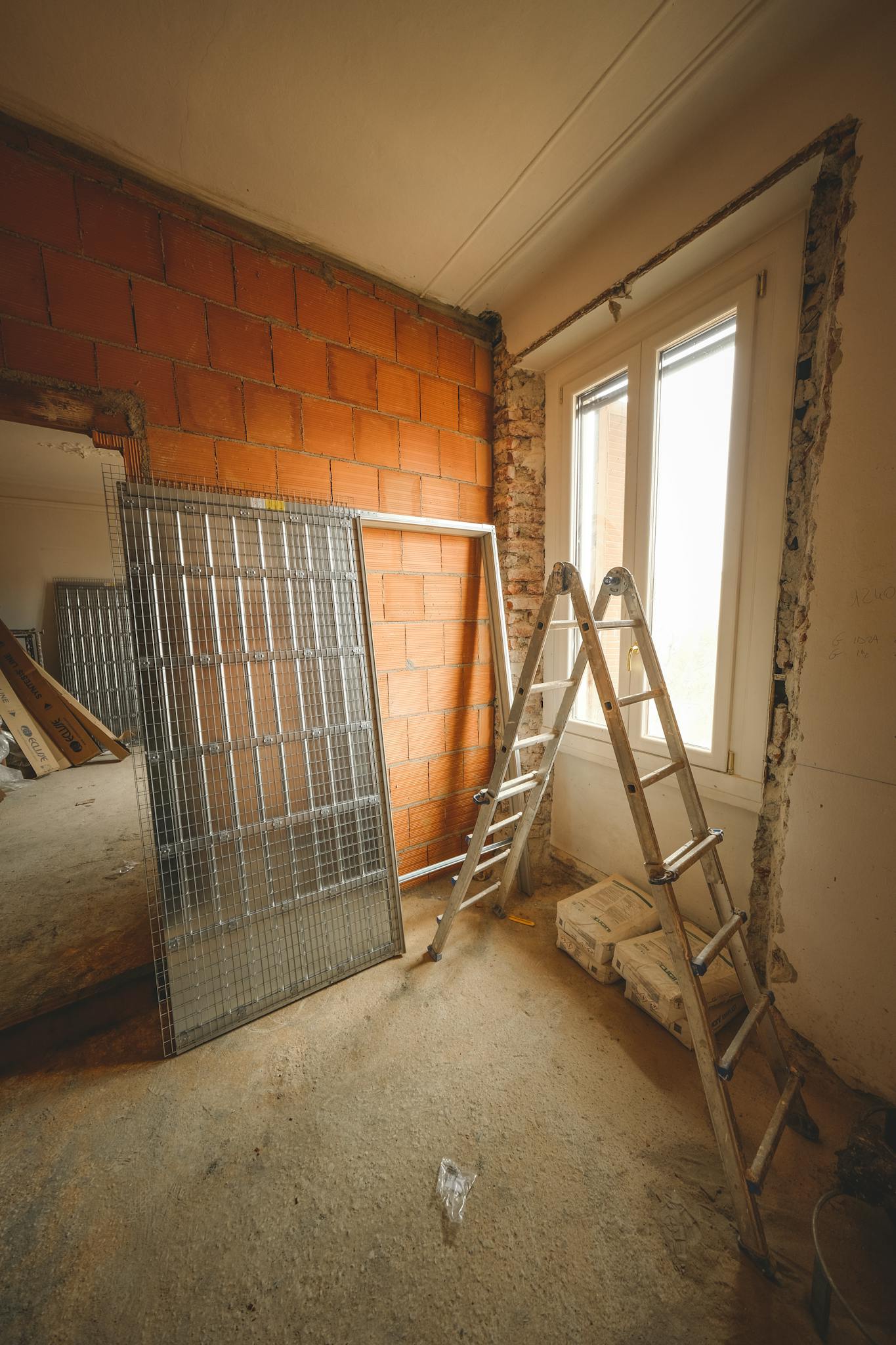 An indoor space showing ongoing refurbishment with ladders and construction materials.